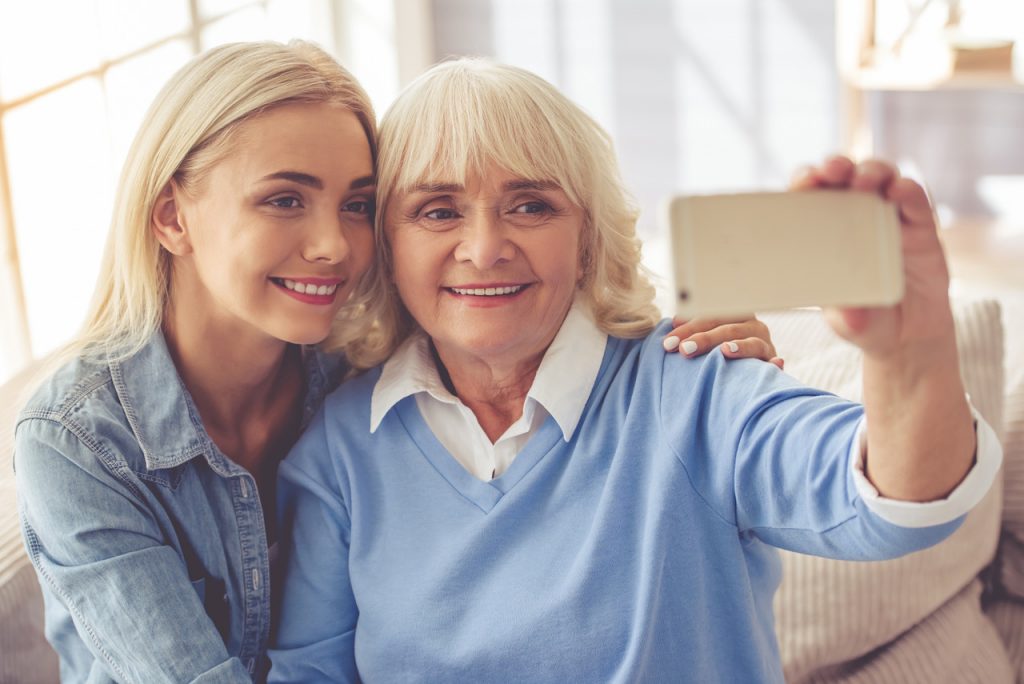 a young woman with her grandmother both posing for a selfie