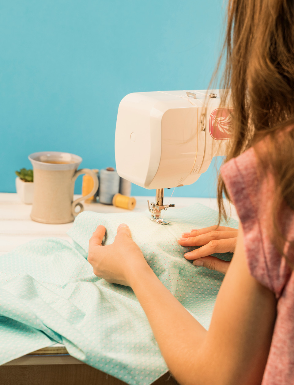 a young girl using a sewing machine