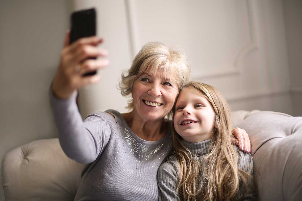 A grandmother watching a phone together with her granddaughter